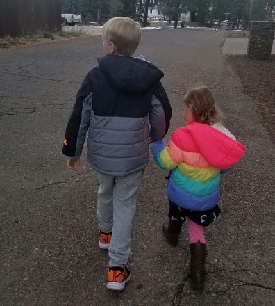 Robyn Brown son wearing a grey trourer and mixed color jacket and her daughter wearing a mixed color jacket as well,